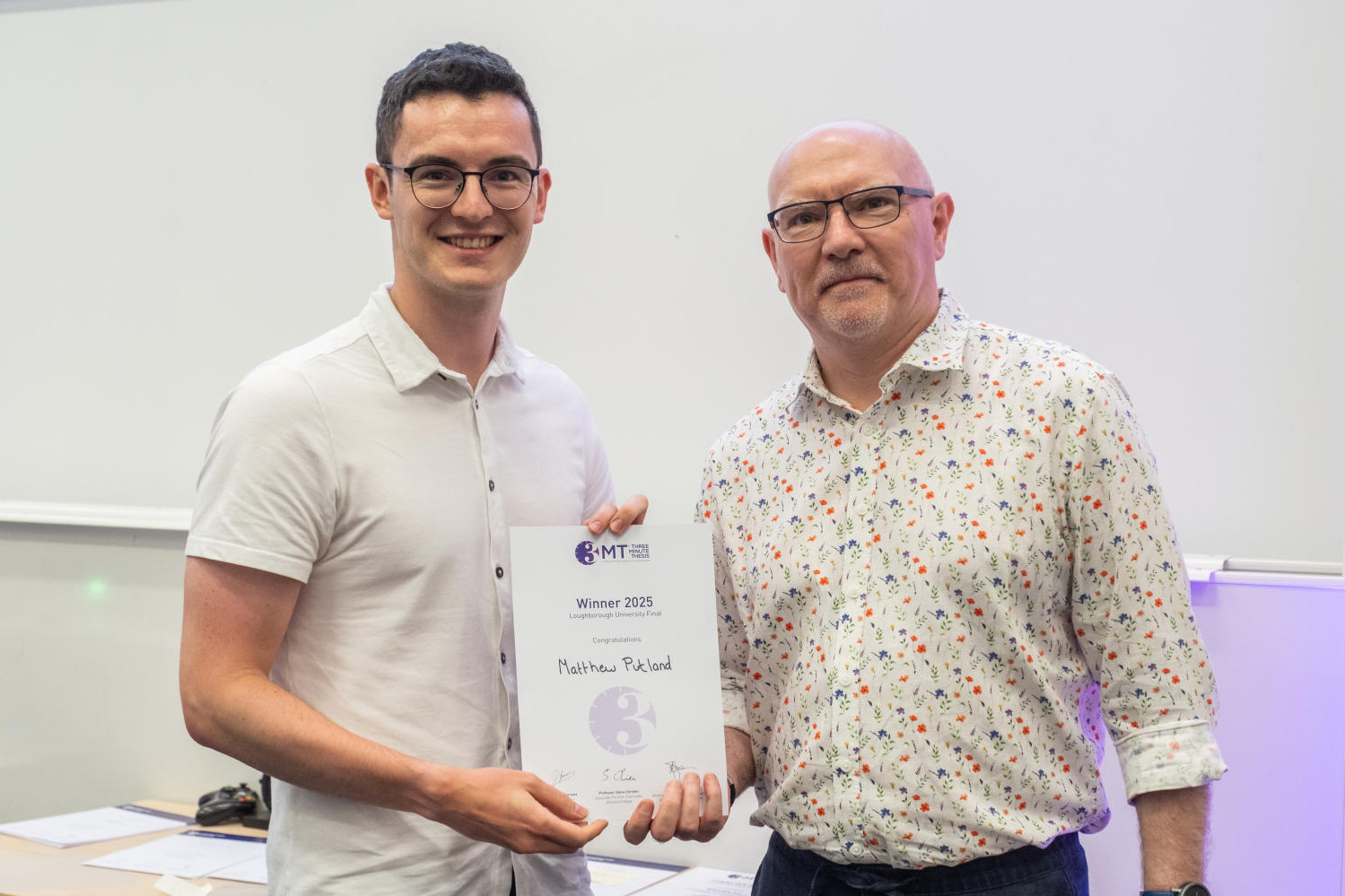 Doctoral researcher Matthew Putland receiving his winning certificate